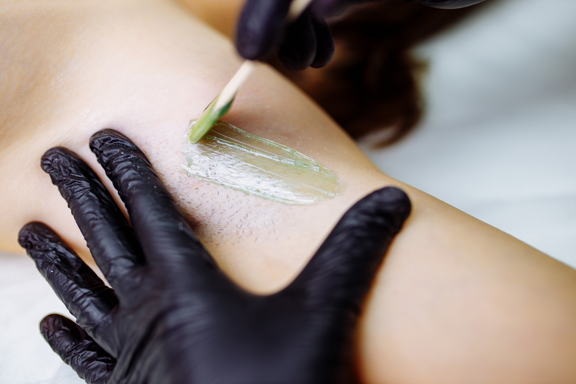 close up waxing arm paids area in studio spa