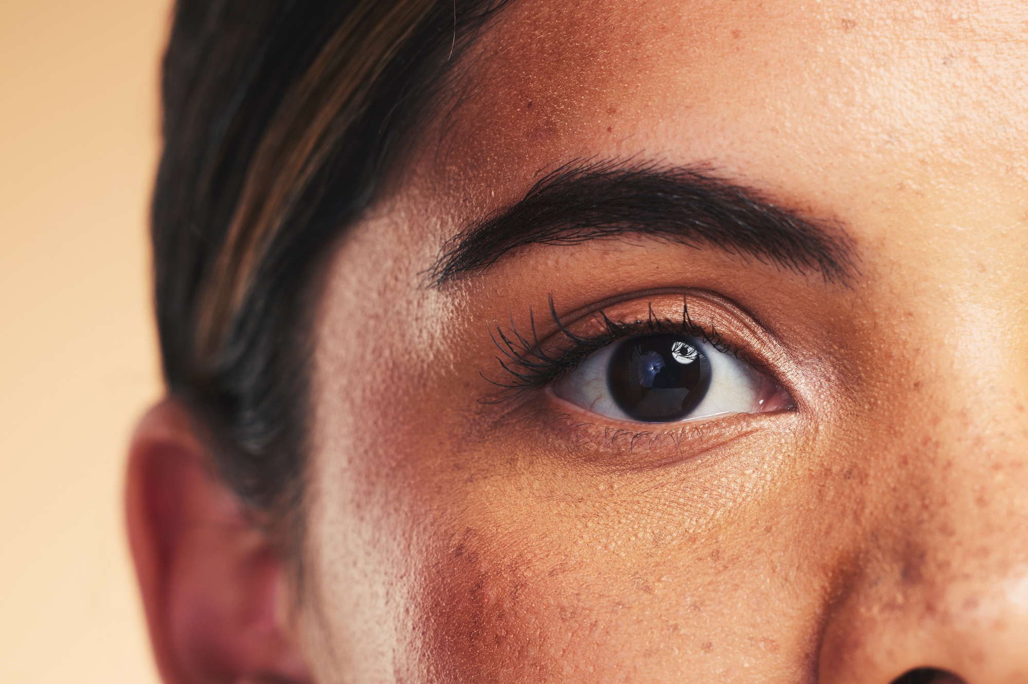 Woman, eye macro and beauty in studio portrait with beauty, cosmetics or natural glow on face by ba